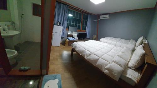 - une chambre avec un grand lit blanc dans l'établissement Green Valley, à Sancheong