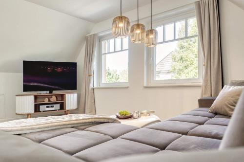 a bedroom with a large bed and a flat screen tv at Mühlenstraße 13 Whg 2 in Zingst