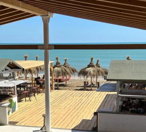 playa home في كاتانيا: اطلالة على شاطئ فيه مظلات والمحيط