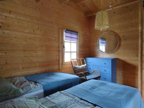 a log cabin with two beds and a mirror at Domki Przy Orzechu in Lubin