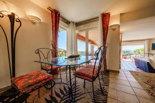 une salle à manger avec une table et des chaises en verre dans l'établissement Villa de charme à Sainte-Maxime avec piscine privée, à Sainte-Maxime