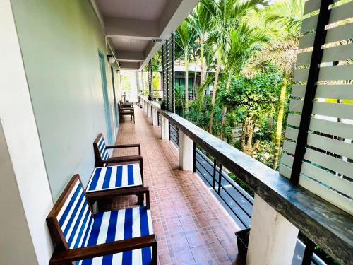 a balcony with blue and white chairs and palm trees at Blue Wave House in Koh Tao
