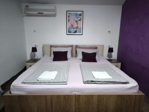 a bedroom with a large bed with two towels on it at Pansion Infinity in Mostar