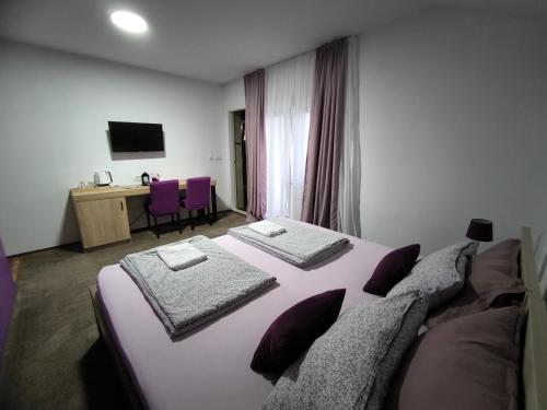 a bedroom with a large bed and a desk at Pansion Infinity in Mostar