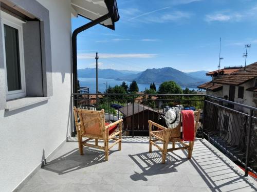 a balcony with two chairs and a view of the mountains at Appartamenti Luna - Stresa in Stresa