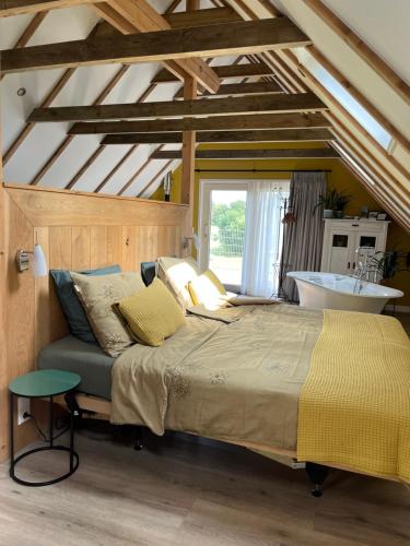 1 dormitorio con 1 cama grande y lavamanos en Hústerheide en Noordbergum
