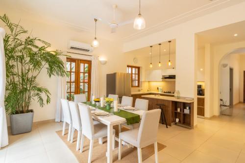 a kitchen and dining room with a table and chairs at ELIVAAS 4 BHK with Pvt Pool in Arpora - Lumin in Goa