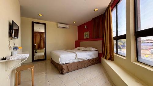 a hotel room with a bed and a window at Hotel Centum in Klang