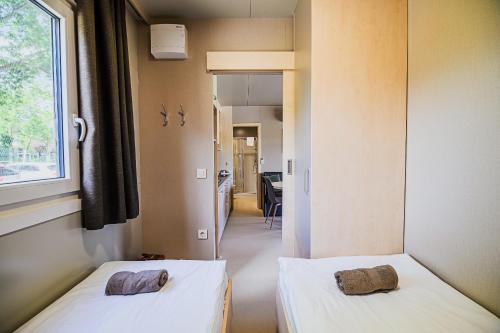 two beds sitting in a room with a window at DELUXE Lake View Mobile Homes with Thermal Riviera Tickets in Čatež ob Savi
