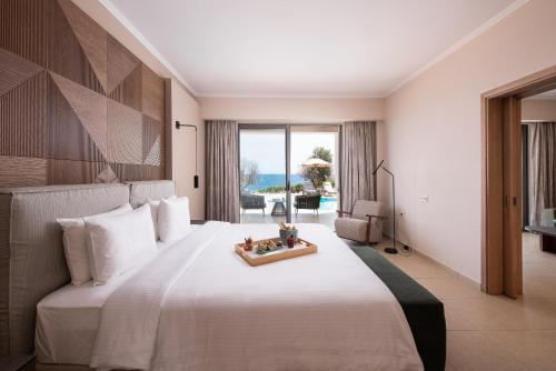 a bedroom with a large white bed with a tray on it at KRESTEN ROYAL Euphoria Resort in Kallithea Rhodes