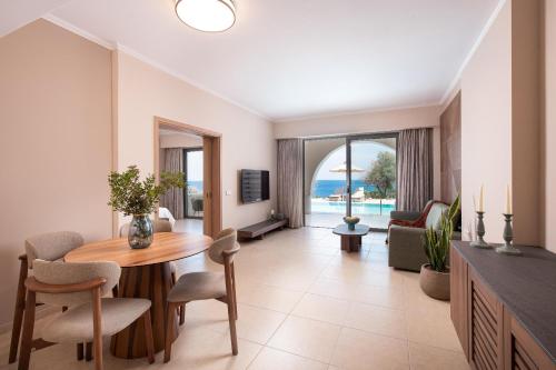 a living room with a table and a couch at KRESTEN ROYAL Euphoria Resort in Kallithea Rhodes