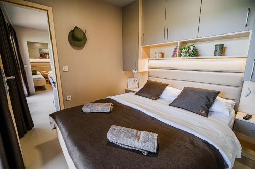 1 dormitorio con 1 cama grande y 2 toallas. en DELUXE Lake View Mobile Homes with Thermal Riviera Tickets en Čatež ob Savi