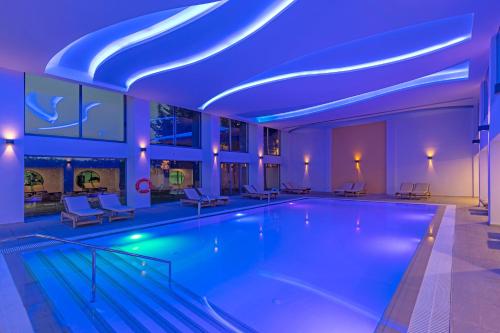 a swimming pool with blue lights in a building at KRESTEN ROYAL Euphoria Resort in Kallithea Rhodes