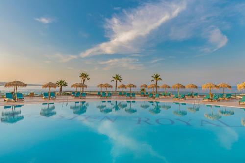 a swimming pool with chairs and umbrellas on the beach at KRESTEN ROYAL Euphoria Resort in Kallithea Rhodes