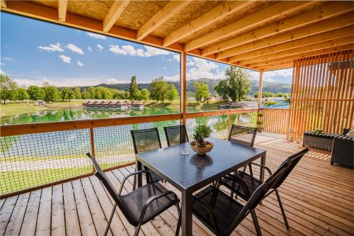 a table and chairs on a deck with a view at DELUXE Lake View Mobile Homes with Thermal Riviera Tickets in Čatež ob Savi