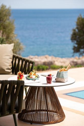 a table with two plates of food on top of it at KRESTEN ROYAL Euphoria Resort in Kallithea Rhodes