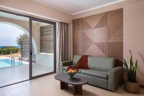 a living room with a couch and a table at KRESTEN ROYAL Euphoria Resort in Kallithea Rhodes