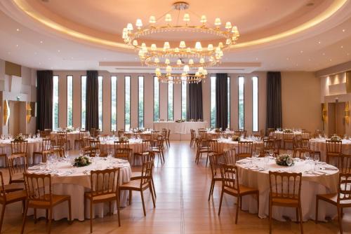 a banquet hall with tables and chairs and a chandelier at KRESTEN ROYAL Euphoria Resort in Kallithea Rhodes