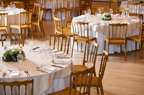 a group of tables with white tablecloths and chairs at KRESTEN ROYAL Euphoria Resort in Kallithea Rhodes