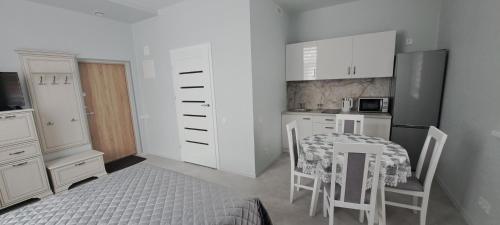 a kitchen with a table and a table and chairs at Apartamentai Mažvydo alėjoje in Klaipėda