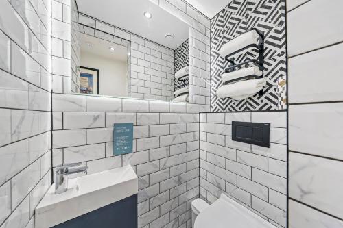 Baño blanco con lavabo y espejo en Vancouver Studios, en Londres