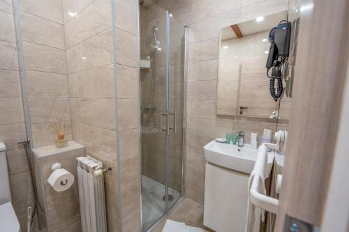 a bathroom with a shower and a toilet and a sink at Hotel Maslina in Seget