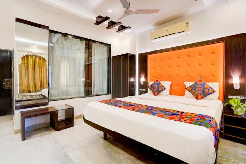 a bedroom with a large bed with an orange headboard at FabHotel Mandiram Palace in Udaipur