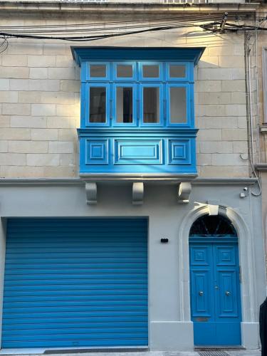 a building with a blue window and two garage doors at Central One bedroom penthouse in Il-Gżira