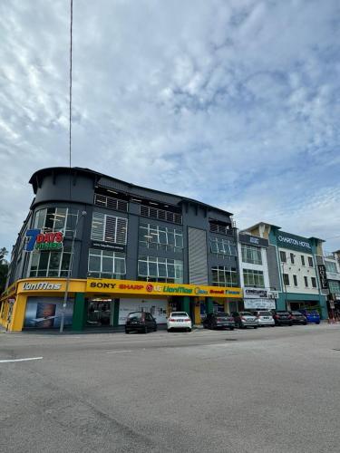 a large building with cars parked in a parking lot at Chariton Hotel Nusa Bestari in Johor Bahru