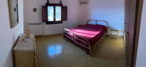 a bedroom with a bed with a purple blanket at sull'arco dell'elefante in Pantelleria