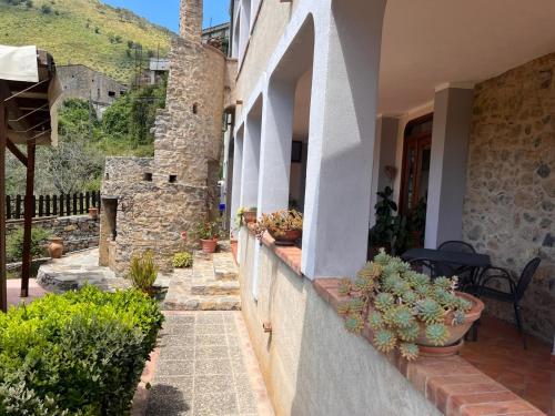 a stone house with a courtyard with potted plants at Country House B&B Antica Dimora Del Sole in Camerota