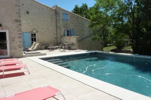 une piscine devant une maison dans l'établissement La Grange des Davids Mas en Provence, à Oppedette