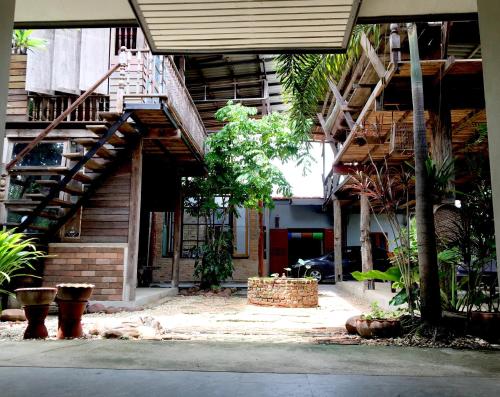 a building with stairs in the middle of a courtyard at Baan Mali Lampang Homestay in Lampang