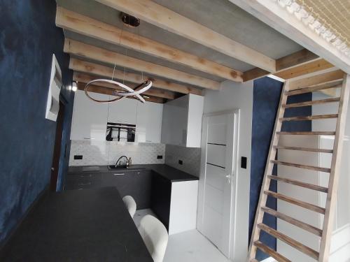 a kitchen with a black table and a staircase at Stania Glamour CENTRUM in Boszkowo-Letnisko