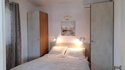 a bedroom with a bed with a light on it at Apartmani Stipe in Drage