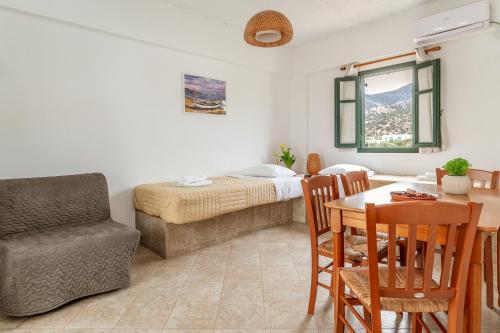 a bedroom with a bed and a table and a chair at Cyclades Beach 3 in Sifnos