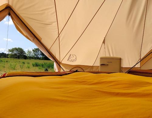 einem nahe gelegenen Zelt mit einem Bett in der Unterkunft Under Canvas Bornholm in Østermarie