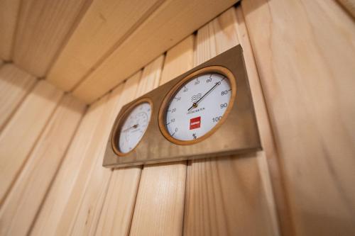 a clock on a wall with two different time zones at Hotel Maslina in Seget