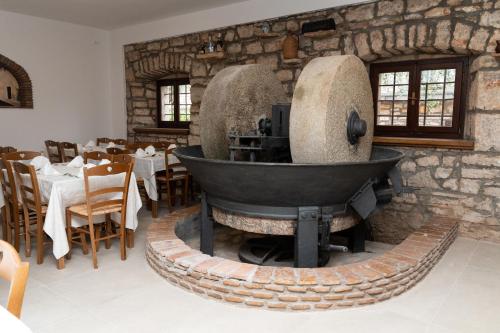 a restaurant with a stone wall with a brick oven at Hotel Maslina in Seget