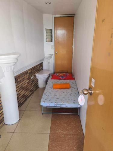 a small bathroom with a bed and a toilet at ASHBURN'S TRANSIENT BAGUIO- BASIC 3rd to 6th floor, NO PARKING, NO ELEVATOR in Baguio
