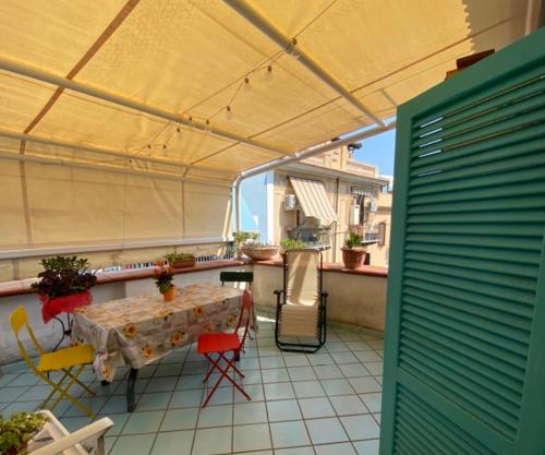 a patio with a table and chairs on a balcony at Caieta: la casa nella roccia in Gaeta