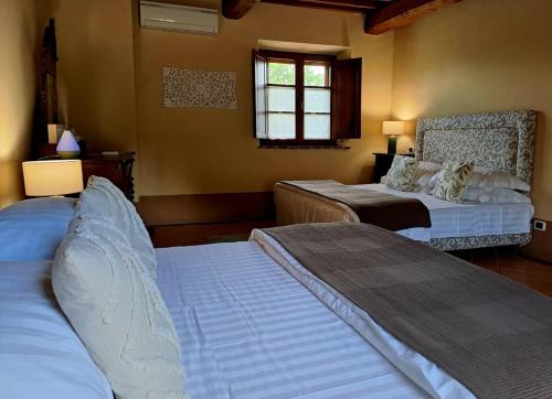 a bedroom with two beds and a window at LaChiusa Tuscany in Montefollonico