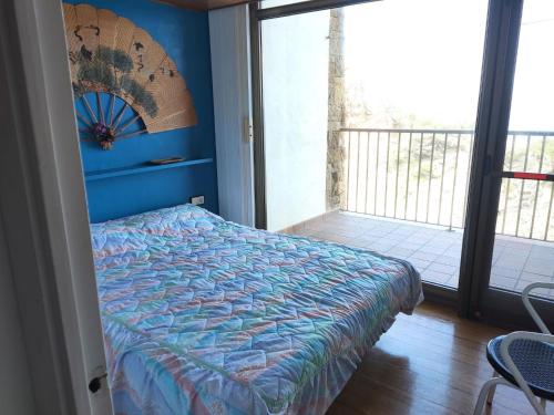 a bedroom with a bed with a blue wall at Apartament CCS 198 in Begur