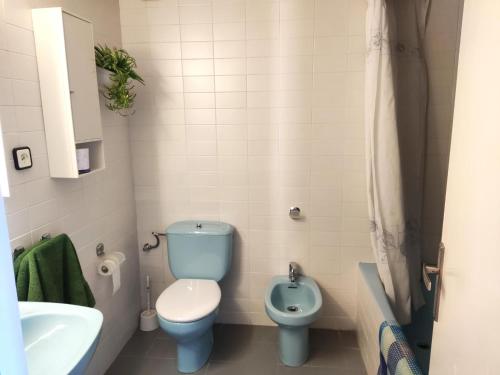 a bathroom with a blue toilet and a sink at Apartament CCS 198 in Begur