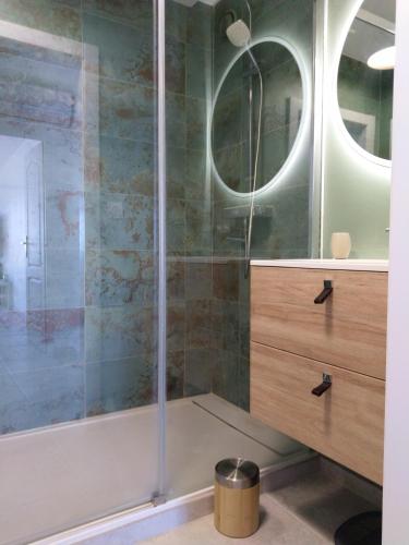 une douche avec une porte vitrée dans une salle de bain dans l'établissement Appartement 40 m2 Vue Mer, à Hyères
