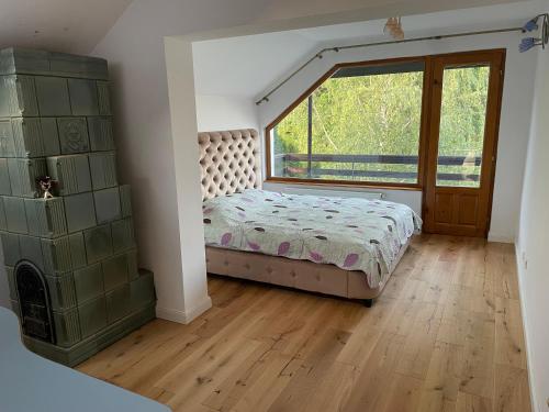 a bedroom with a bed and a large window at VILLA BY THE LAKE in Curtea de Argeş