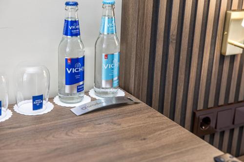 two bottles of water sitting on top of a wooden table at Gradiali Wellness and SPA in Palanga