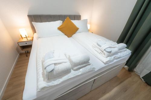 a large white bed with towels on it at Hotel Maslina in Seget