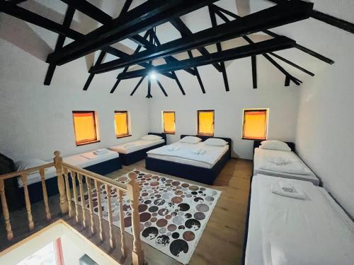 a room with three beds and a staircase with windows at Small Bosnian House in Bihać