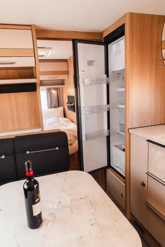 a bottle of wine sitting on a table in a caravan at אבן על הנחל in Merhav Am